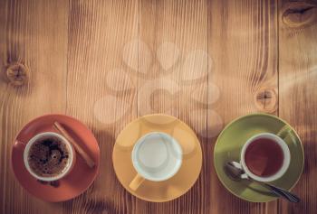 cup of tea, milk, coffee on wooden background