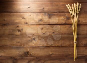 ears of wheat on wooden plank background texture