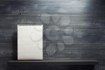 checked notebook at shelf wooden  background texture