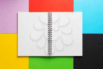 checked notebook at abstract colorful paper background texture