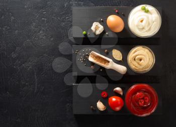 tomato sauce, mayonnaise and mustard in bowl on wooden background