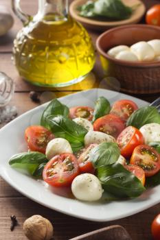 caprese salad in plate at wooden  background