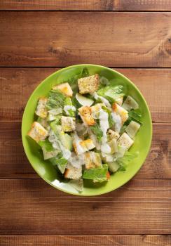 caesar salad in plate at wooden  background