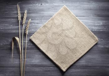 ears of wheat and cloth on wooden background