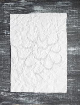 empty white wrinkled paper at wooden background