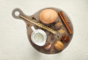 sprinkled flour and bakery ingredients on wooden background, top view
