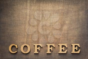 coffee letters at old wooden background, top view