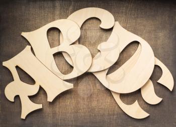 wooden letters at plywood background, top view