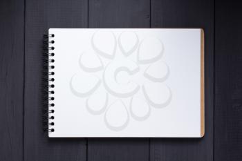 notepad at black wooden background surface table, top view