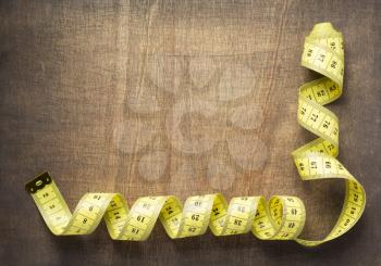 tape measure on wooden table background, top view