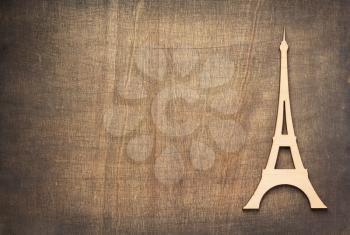 wooden eiffel tower toy at plywood background surface