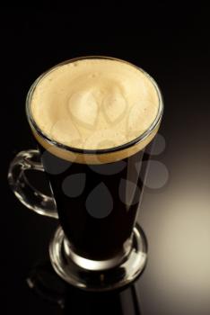 coffee in glass cup on black glossy background