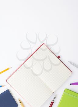 paper notebook and school supplies at white background