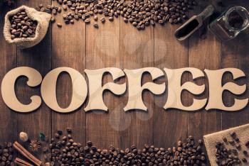 coffee letters and beans on wooden table background, top view