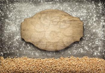 wheat grains and sign board at wooden background, top view