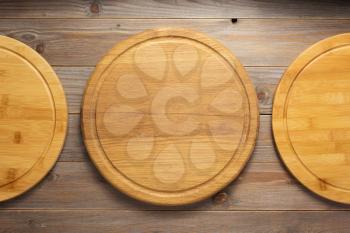 pizza cutting board at rustic wooden plank background, top view