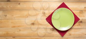 plate and napkin cloth at rustic wooden plank board table background, top view