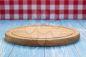 pizza cutting board and napkin tablecloth at rustic wooden table, in front plank background