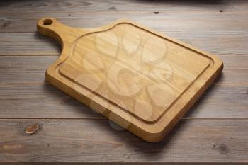 pizza cutting board at rustic wooden table in front plank background