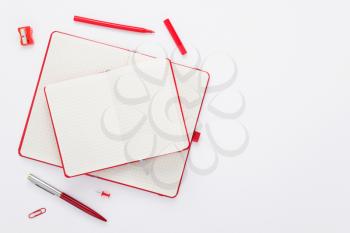 notebook and stationary at white paper background, top view