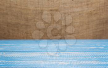 wooden board plank table and burlap hessian sacking background, table in front view