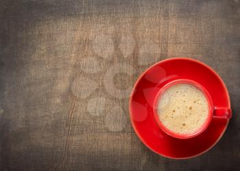 cup of coffee on dark wooden background, top view