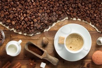 coffee beans and cup on wooden background, top view