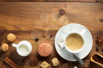 cup of coffee and ingredients at wooden background, top view