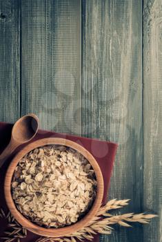 bowl of oat flakes at wooden background