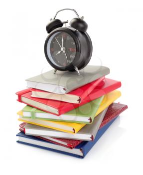 notebooks and alarm clock isolated at white background