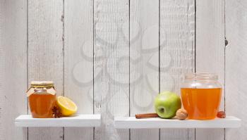 glass jar of honey on wooden shelf background