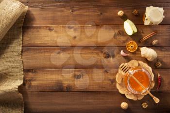 glass jar of honey on wooden background