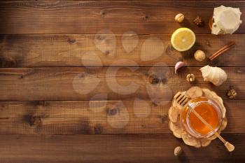glass jar of honey on wooden background