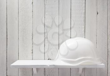 construction helmet on wooden shelf