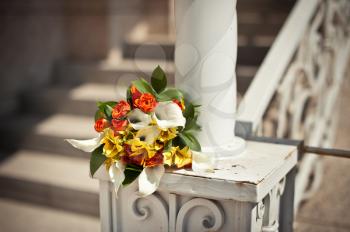 Bouquet on a handrail. Beautiful white shod handrail of a ladder.
