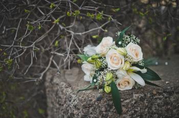 Bouquet from beige roses on a concrete plate.