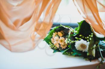 The wedding bouquet lies on a table.