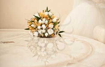 Bouquet on a table. A beautiful beige table with reflection of a bouquet
