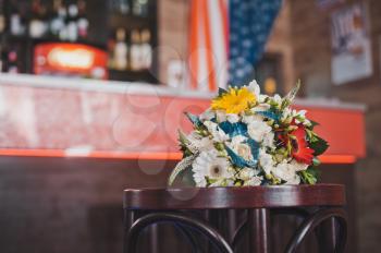 The bunch of flowers lies in a bar on a chair.