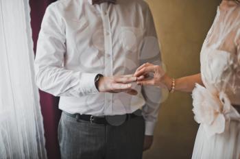 Newly-married couple exchanges wedding rings.