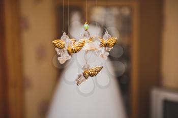 Figures of angels hang against a dress.
