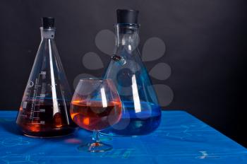 Liquids in flasks on a table.