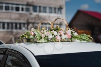 Ornaments on a car roof in the form of rings with hand bells on wedding.