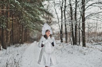 The girl in the winter wood on a footpath.