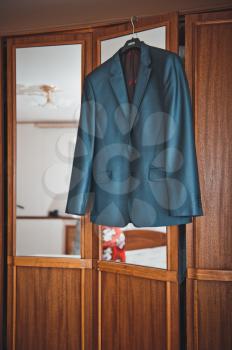 The suit hangs on a hanger in a case.