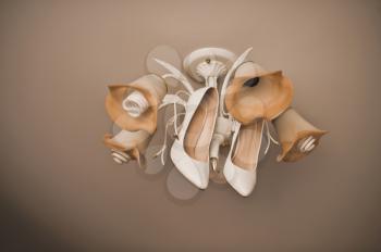 Shoes on a chandelier under a ceiling.
