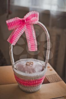 Beautiful basket for wedding gold rings with pink bows.