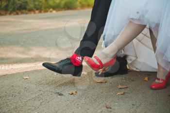 Feet of the newly-married couple in the course of walking.