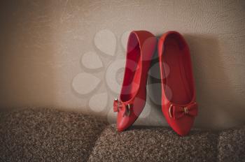 Beautiful red shoes against a wall.