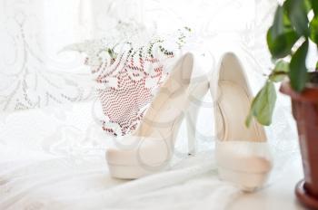 White wedding shoes on a window sill.
